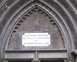 Figure 4 : Tympan de la cathédrale de Clermont-Ferrand. Une restauration a permis de dégager cette marque à la peinture, où l’on lit : « Le peuple français reconnaît l’Être suprême et l’immortalité de l’âme » (image WikiCommons auteur Romary)